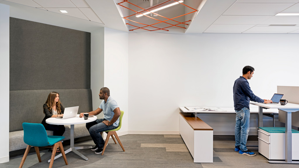 A man standing in front of a woman seated at a table.